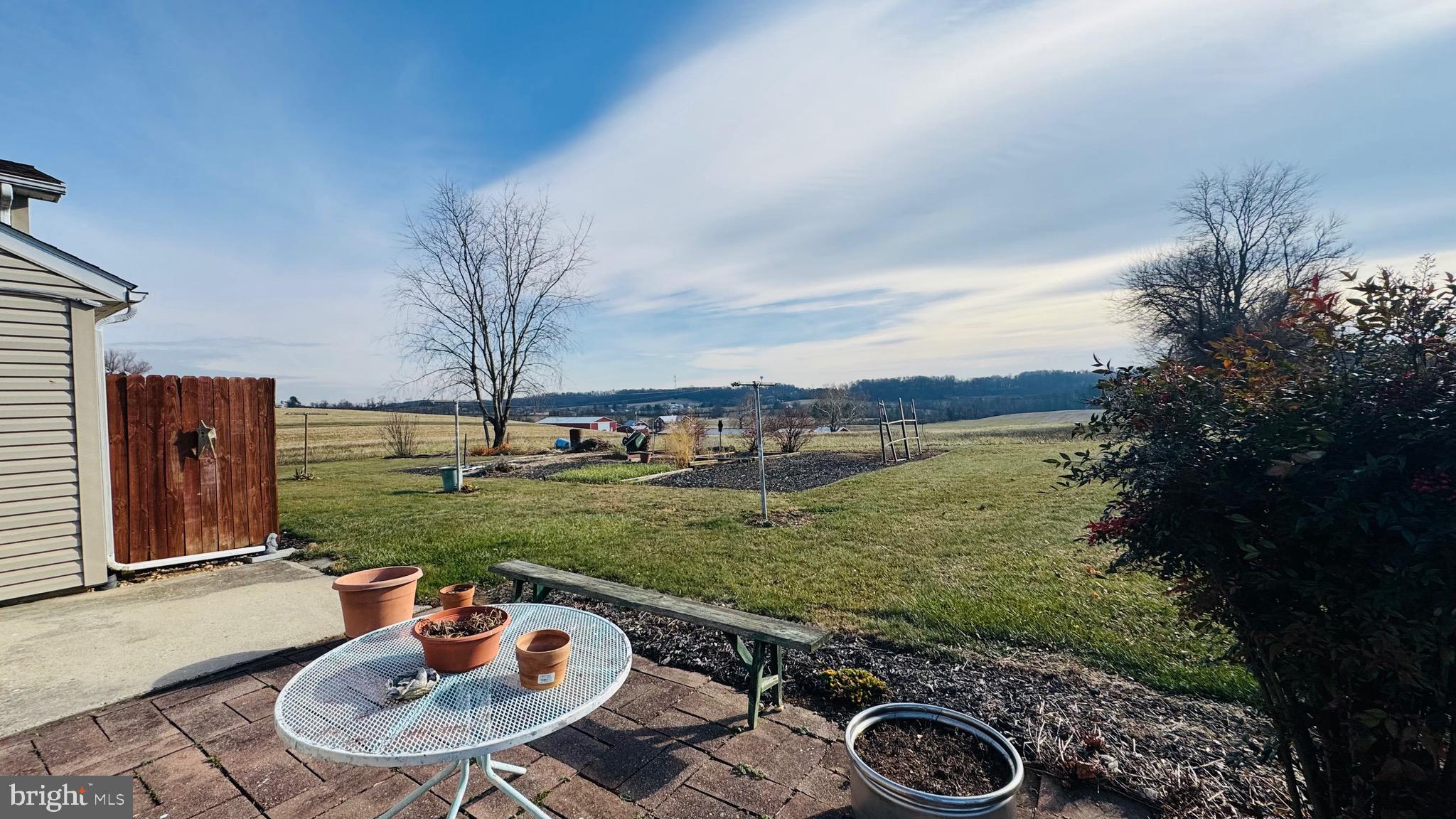 2311 Bachmans Valley Road Manchester, MD 21102 - Photo 3 of 6 a view of a backyard with table and chairs potted plants and wooden floor