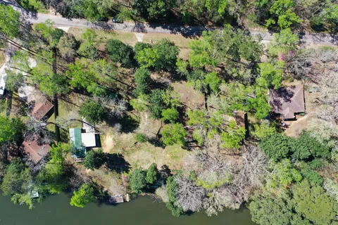 an aerial view of residential house with outdoor space and trees all around