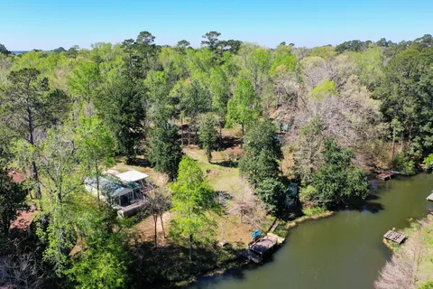 an aerial view of residential house with outdoor space and trees all around