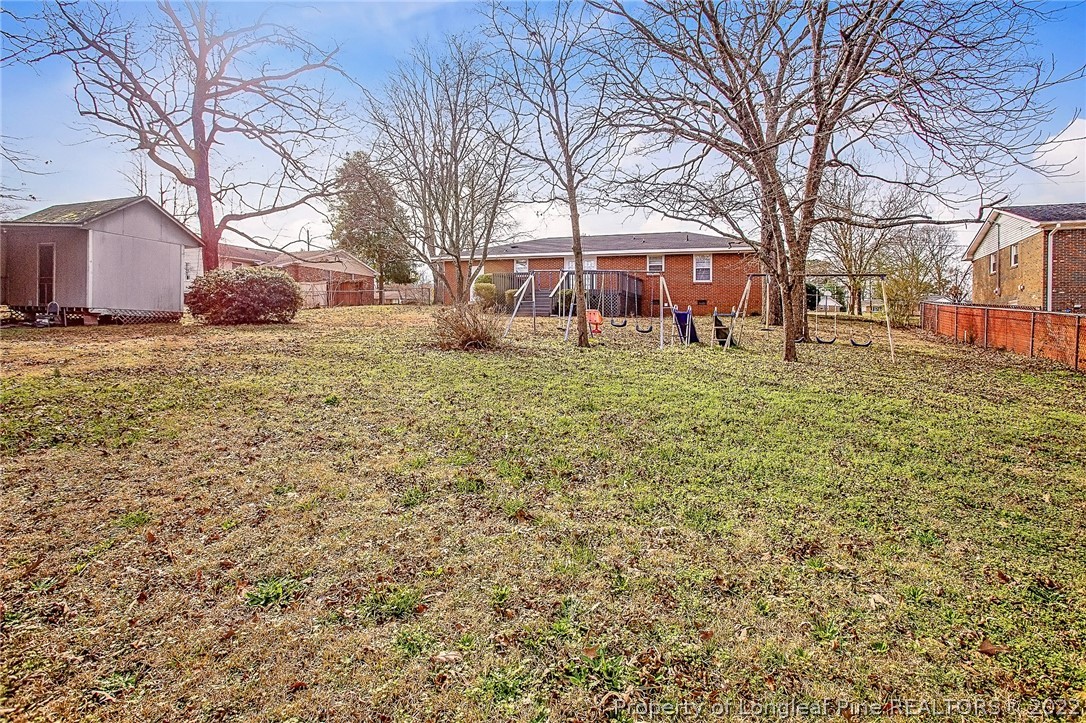 660 Pleasant Loop Fayetteville, NC 28311 - Photo 32 of 35 a backyard of a house with large trees and outdoor seating