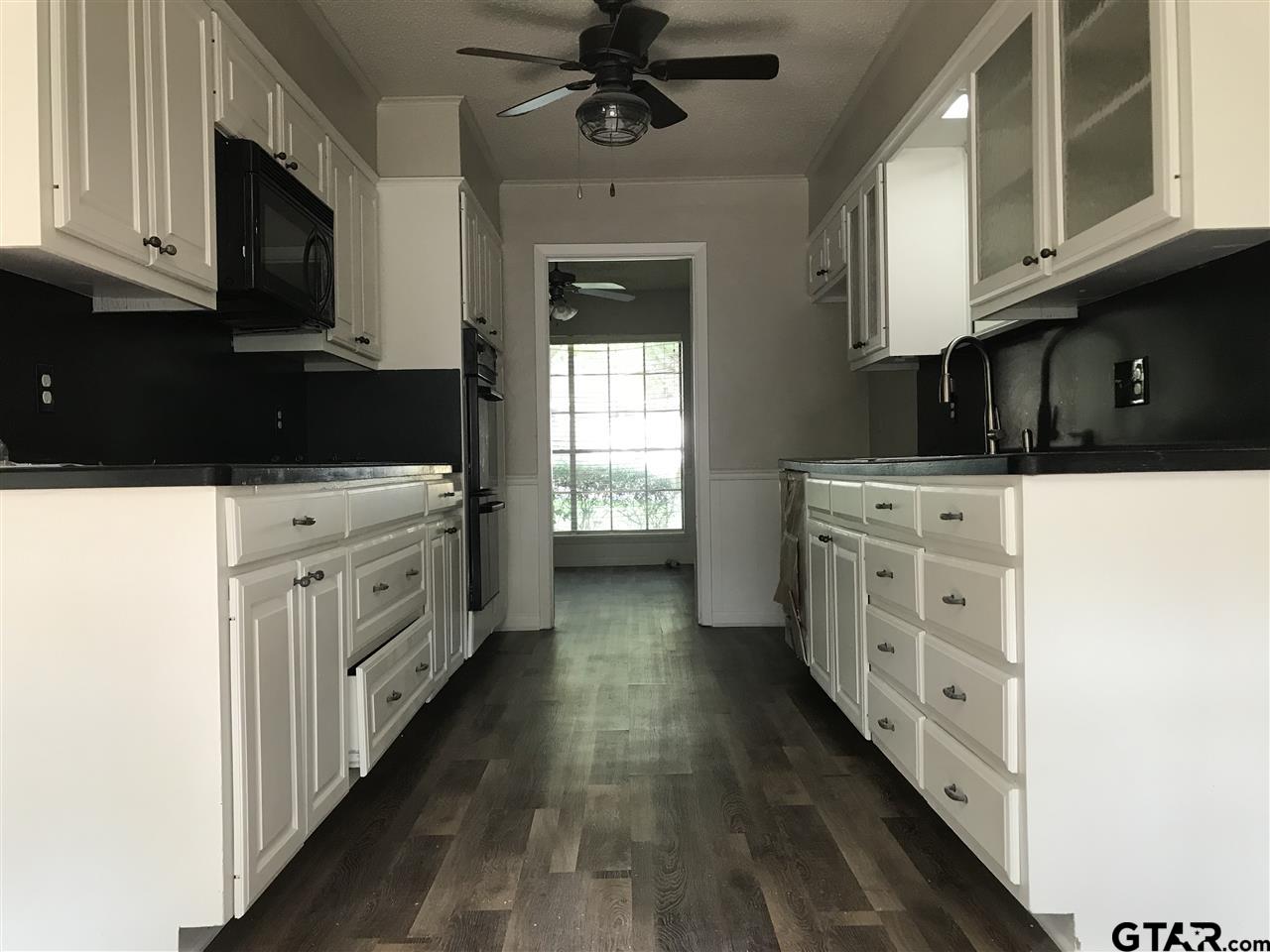 8233 Clemson Drive Tyler, TX 75703 - Photo 2 of 6 a kitchen with stainless steel appliances a stove microwave and cabinets