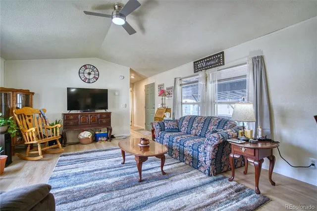 a living room with furniture a flat screen tv and a window