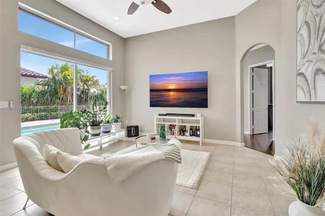 a living room with furniture a flat screen tv and a large window