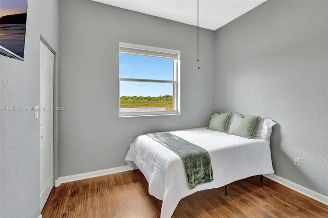 a bedroom with a bed and a painting on the wall