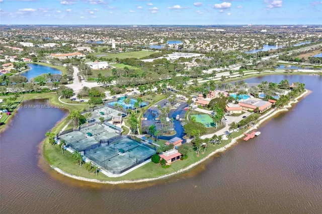 a view of a swimming pool with a lawn chairs and palm trees