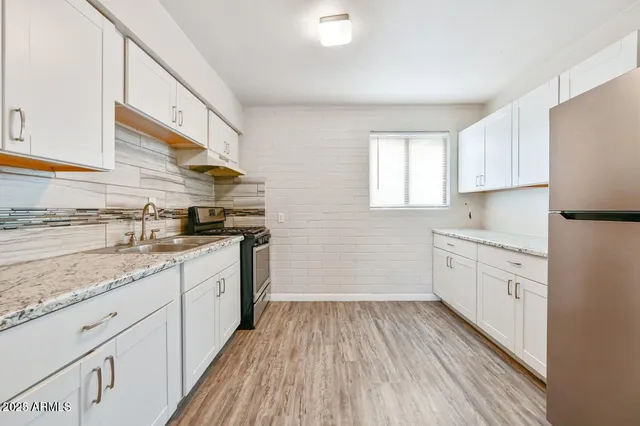 a kitchen with granite countertop wooden cabinets and white appliances