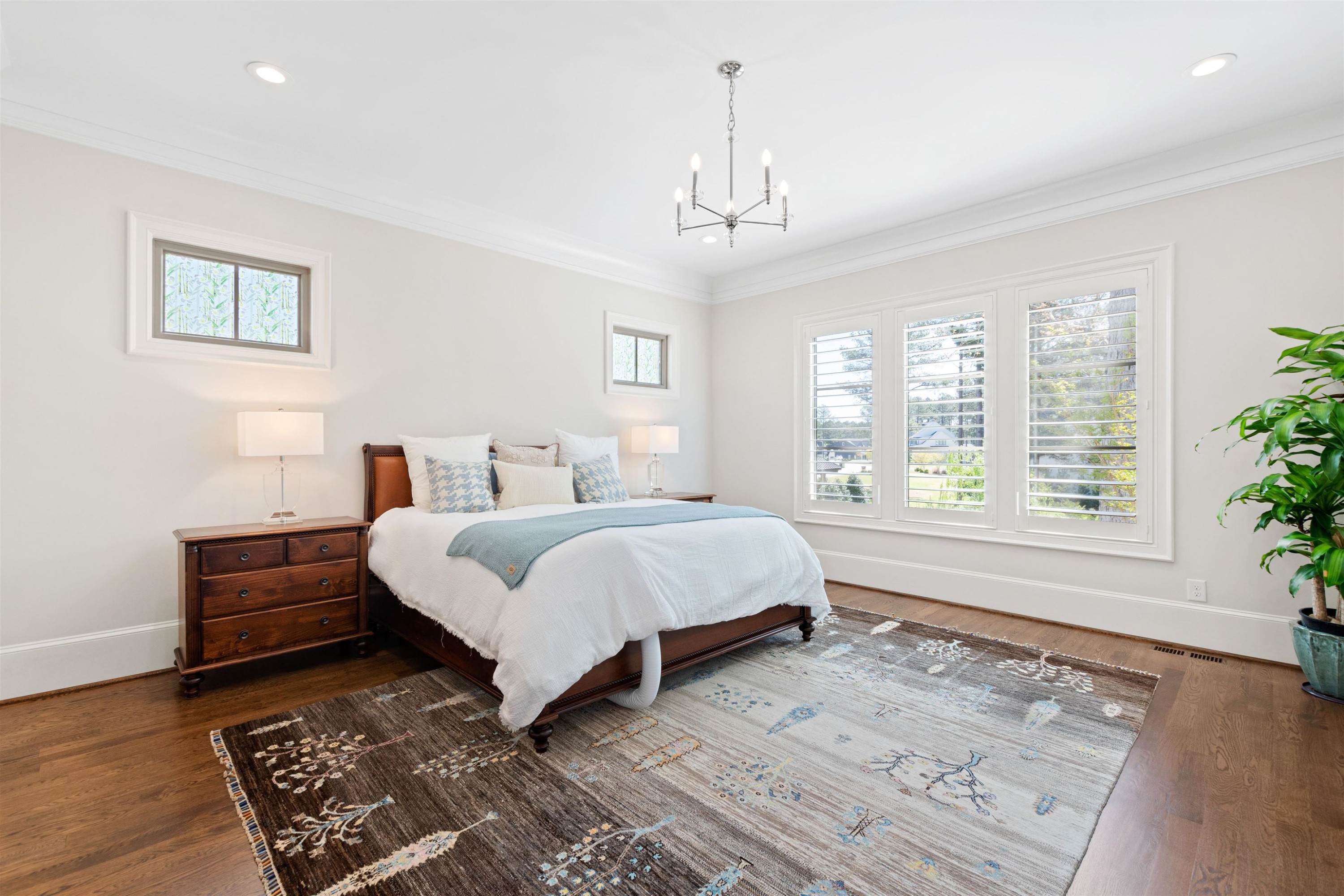 10340 Grafton Road Raleigh, NC 27615 - Photo 33 of 70 a spacious bedroom with a bed a window and potted plant on the dresser