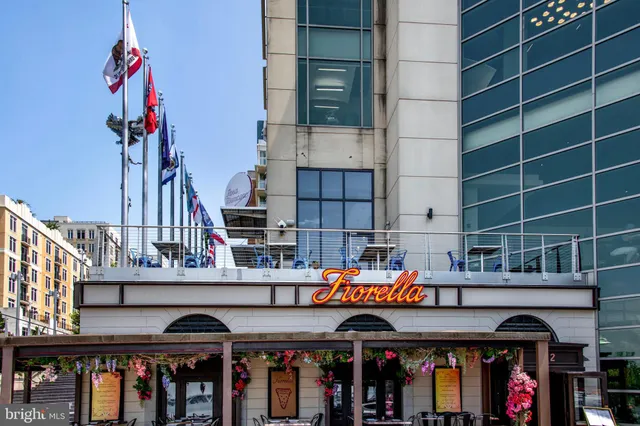 a view of a building with a couple of people sitting under an umbrella