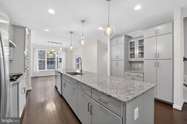 a kitchen with kitchen island a sink stove and refrigerator