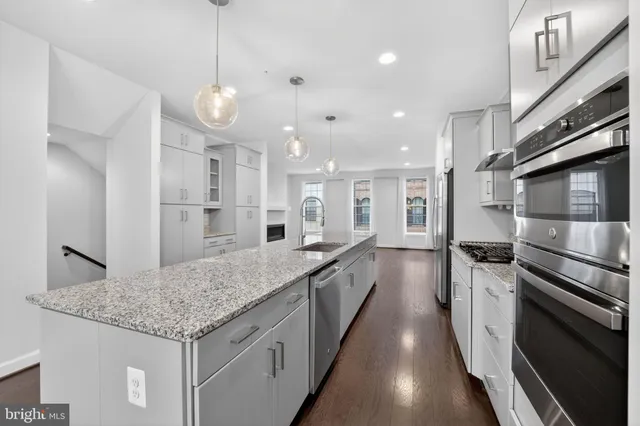 a kitchen with stainless steel appliances granite countertop a sink stove and refrigerator