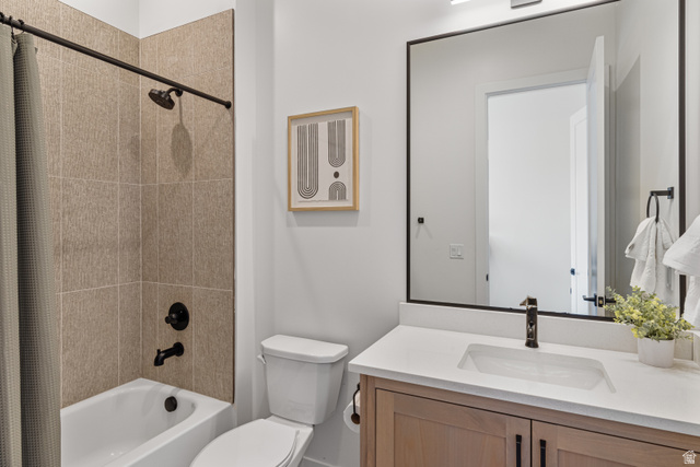 5367 Cyan Lane St. George, UT 84790 - Photo 2 of 49 Bathroom featuring a light wood-finish vanity with a white countertop and integrated sink, a rectangular framed mirror, and a shower-over-tub combination with large format tiled walls and matte black fixtures