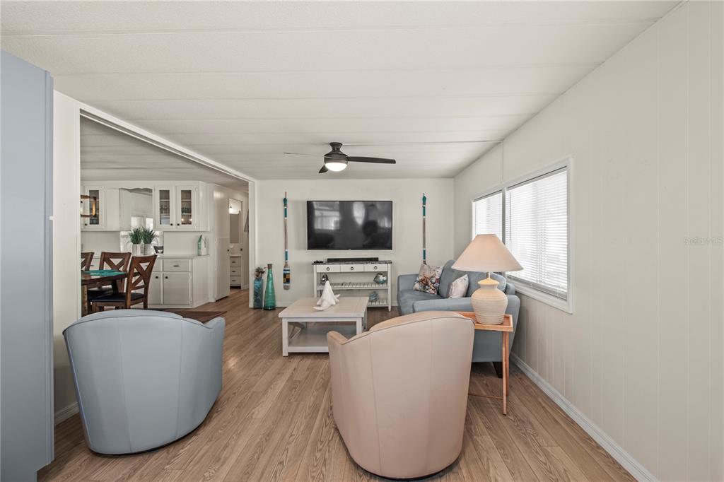 4902 91st Lane North St. Petersburg, FL 33708 - Photo 17 of 41 a living room with furniture a flat screen tv and a large window