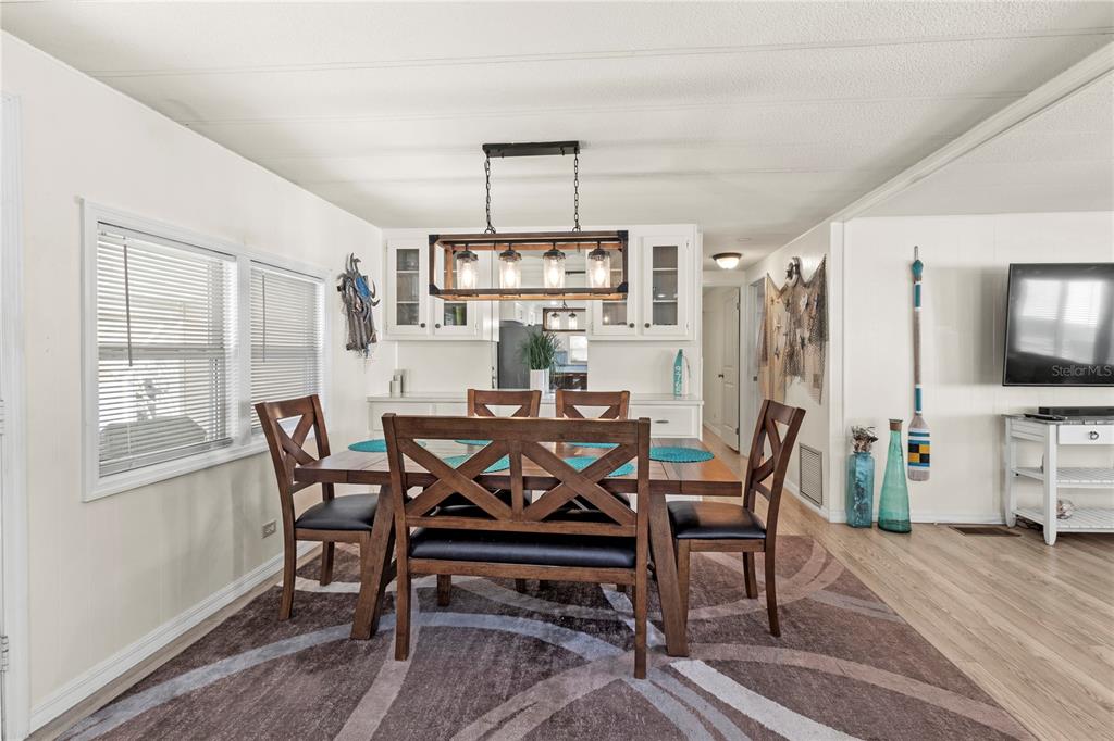 4902 91st Lane North St. Petersburg, FL 33708 - Photo 18 of 41 a view of a dining room with furniture window and wooden floor