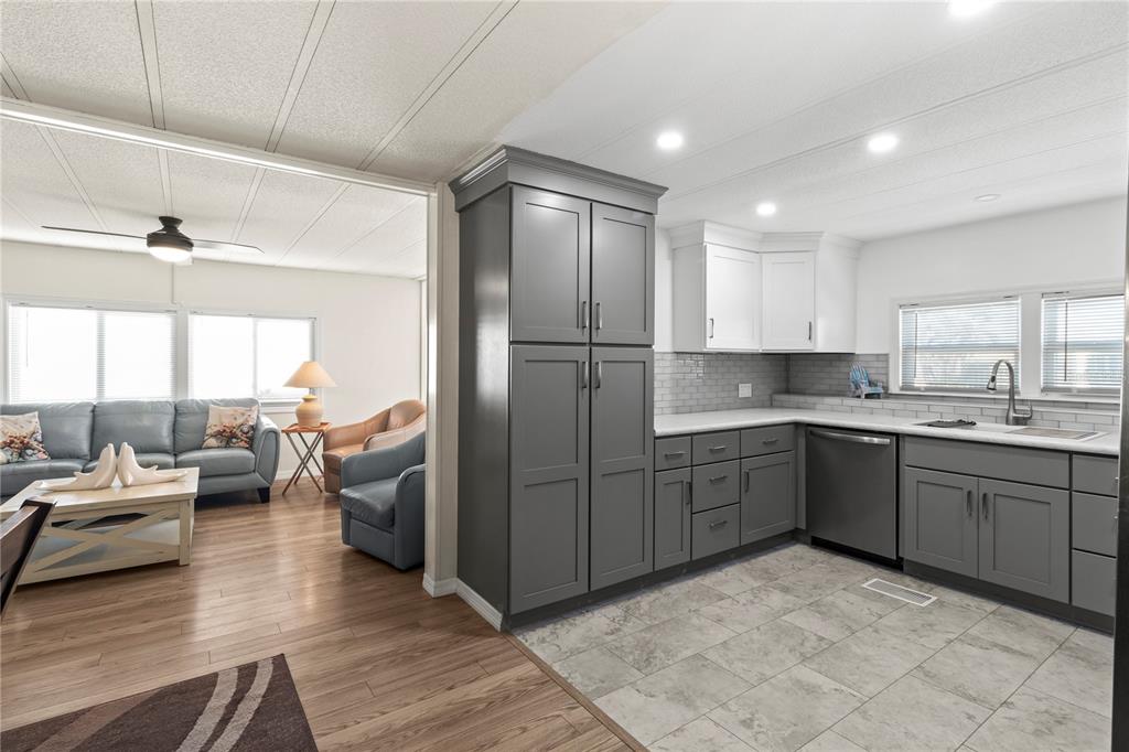 4902 91st Lane North St. Petersburg, FL 33708 - Photo 19 of 41 a kitchen with sink refrigerator and cabinets