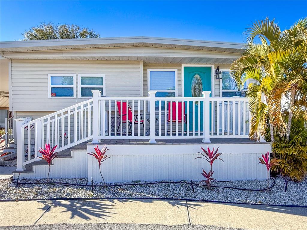 4902 91st Lane North St. Petersburg, FL 33708 - Photo 33 of 41 a view of a wooden house with a small yard and a large tree
