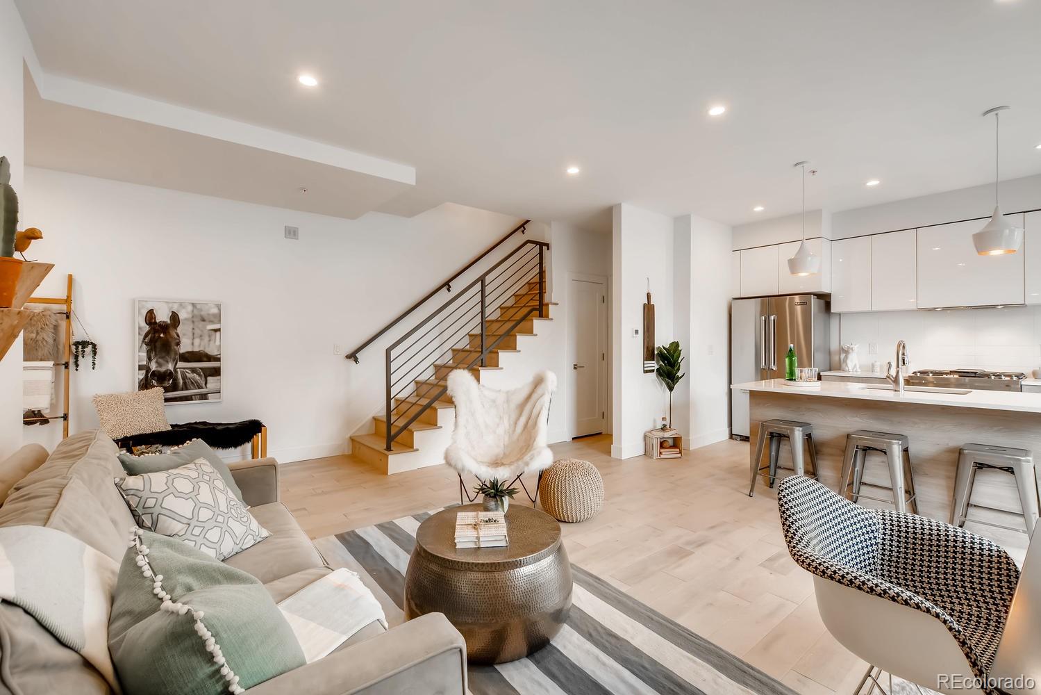 234 Inca Street Denver, CO 80223 - Photo 3 of 27 a living room with furniture kitchen view and a wooden floor