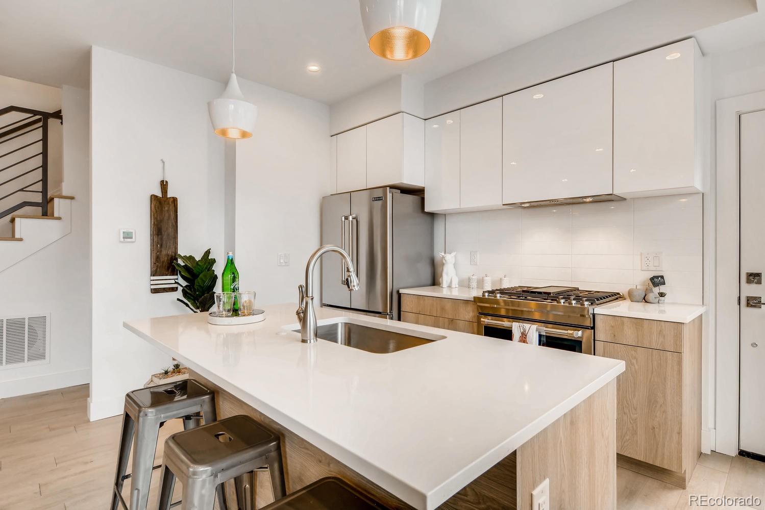 234 Inca Street Denver, CO 80223 - Photo 4 of 27 a kitchen with stainless steel appliances a sink a table and chairs
