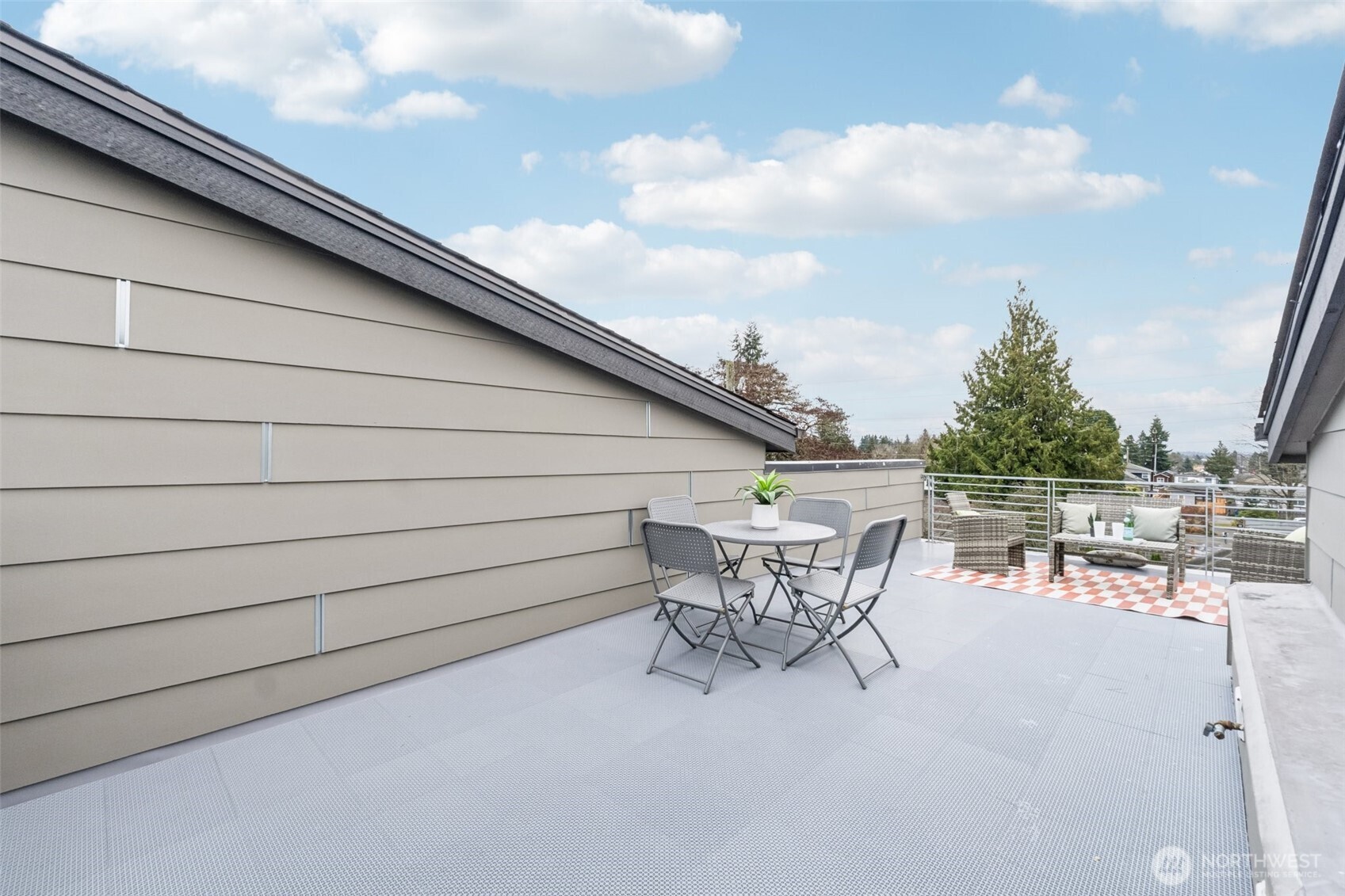 10503 Evanston Avenue North, Unit C Seattle, WA 98133 - Photo 21 of 25 a roof deck with table and chairs and potted plants with wooden floor
