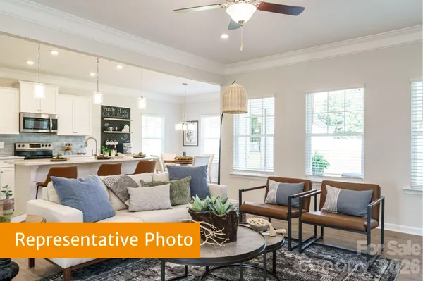 a living room with furniture wooden floor and a large window