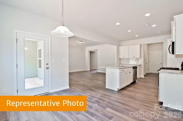 a view of kitchen with stainless steel appliances granite countertop cabinets and wooden floor
