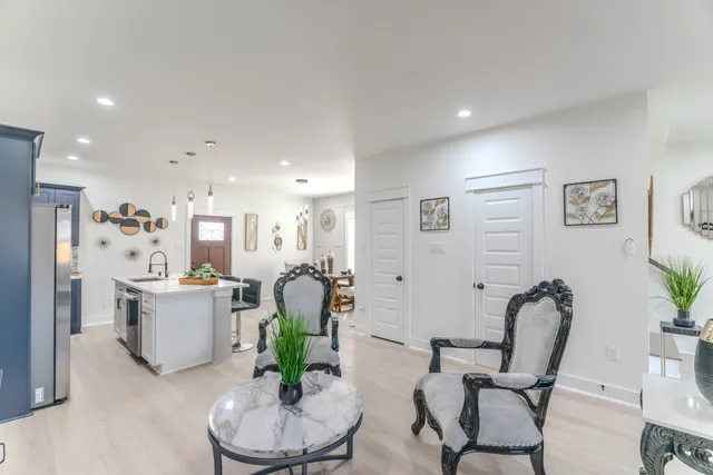 a living room with furniture and a dining table with potted plant