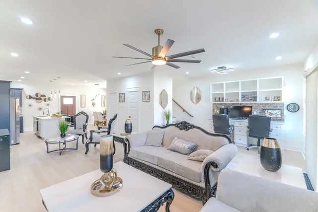 a living room with furniture kitchen view and a chandelier