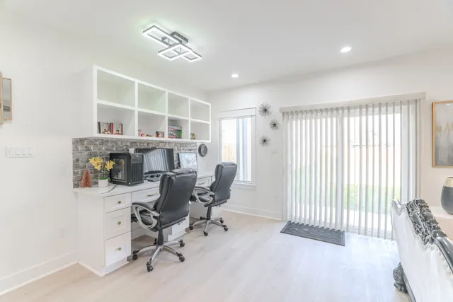 a view of a workspace with furniture and a window