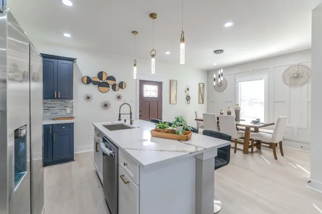 a kitchen with stainless steel appliances granite countertop a refrigerator and a stove top oven with wooden floor