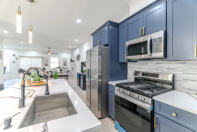 a kitchen with stainless steel appliances kitchen island granite countertop a stove and a refrigerator