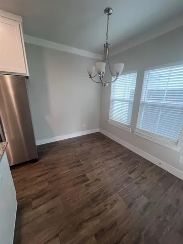 a large kitchen with stainless steel appliances a refrigerator and wooden floor