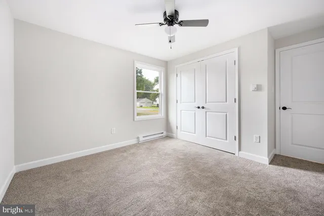 an empty room with windows and cabinet