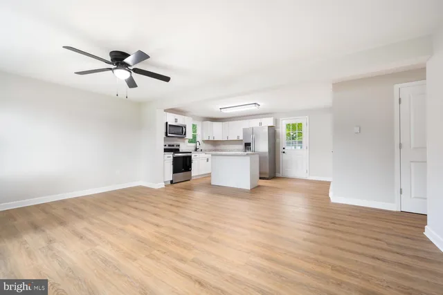 a view of a kitchen with wooden floor and a ceiling fan