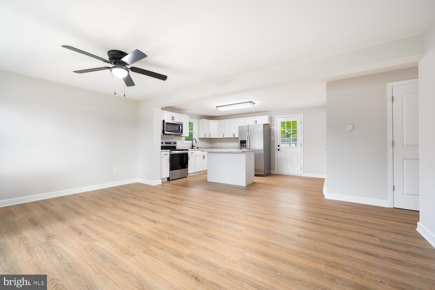 14 North Maple Avenue Ridgely, MD 21660 - Photo 4 of 19 a view of a kitchen with wooden floor and a ceiling fan