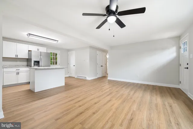 a view of an empty room and window wooden floor and cabinet
