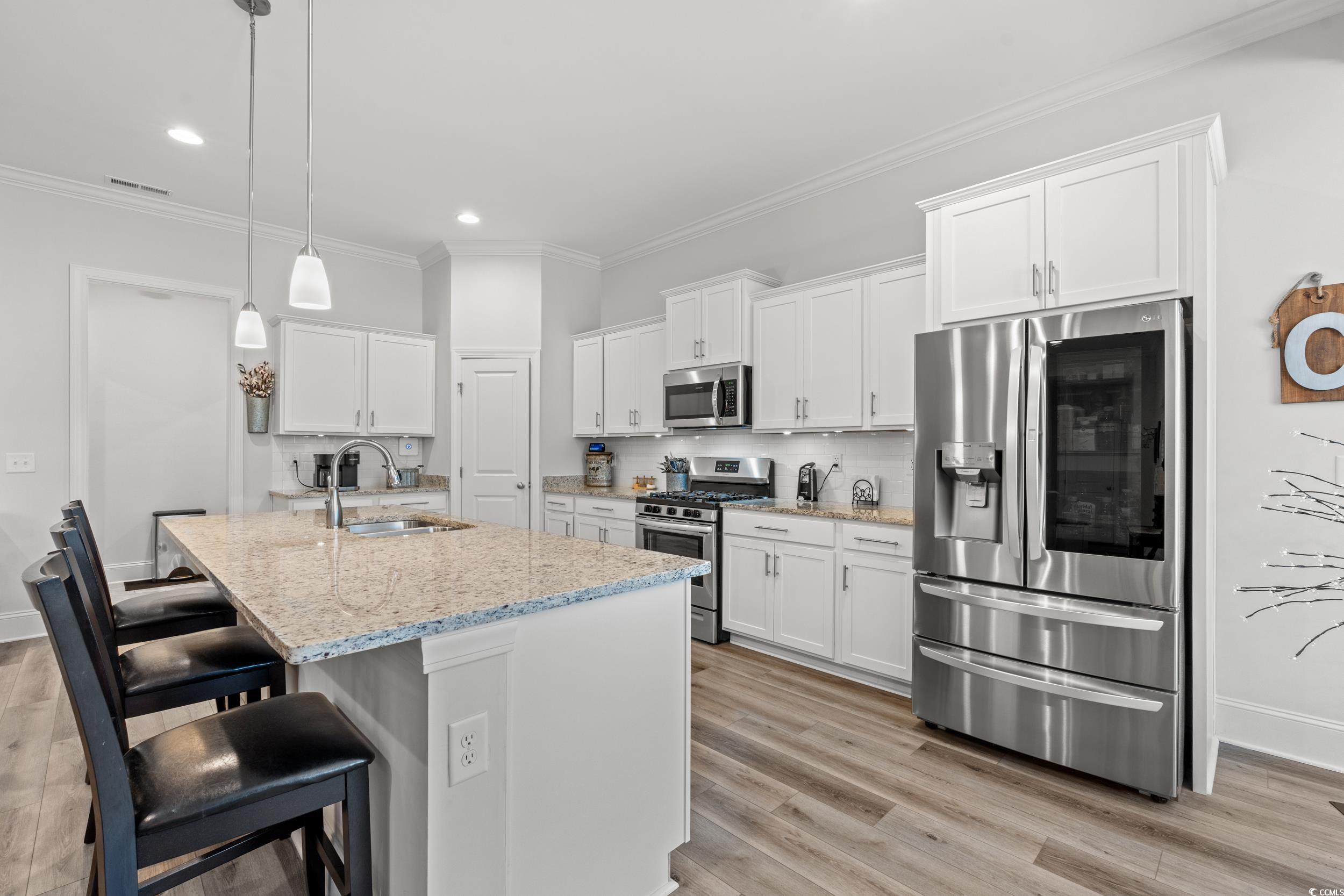 641 Indigo Bay Circle Myrtle Beach, SC 29579 - Photo 11 of 39 Kitchen featuring sink, white cabinetry, hanging l