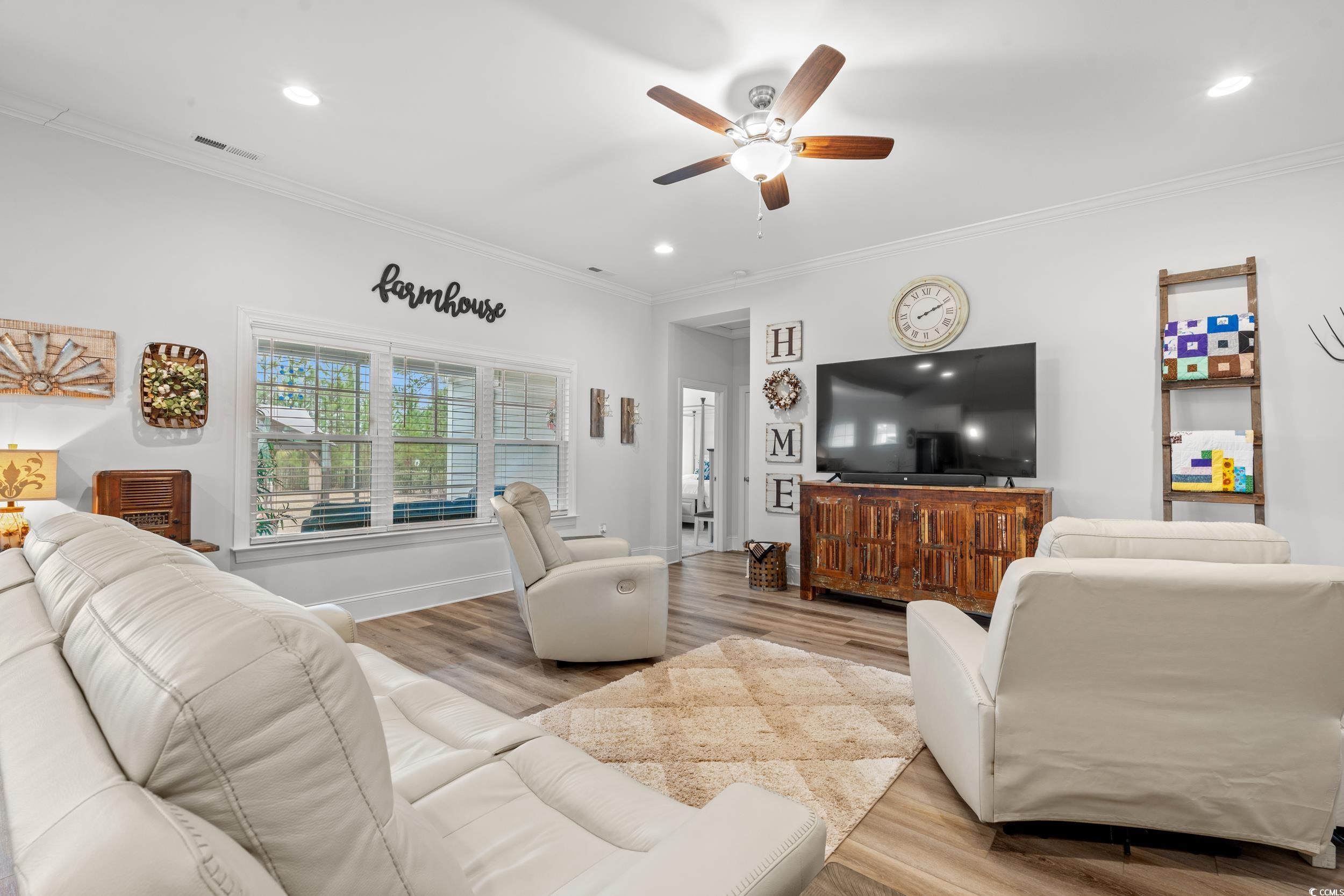 641 Indigo Bay Circle Myrtle Beach, SC 29579 - Photo 7 of 39 Living room with crown molding, ceiling fan, and l