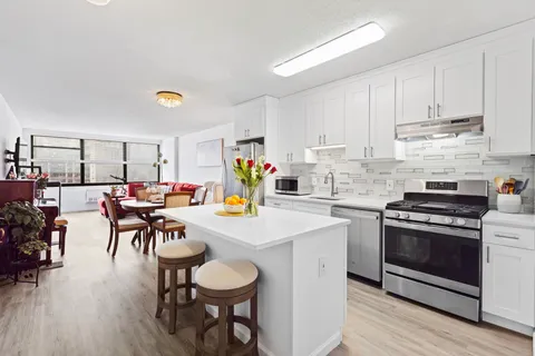 a kitchen with a table chairs stove and cabinets