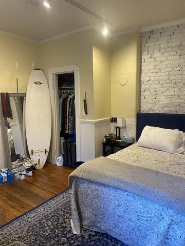 a bedroom with a bed a mirror and gym equipment