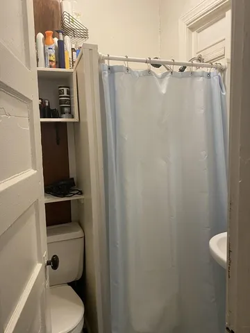 a bathroom with a shower a toilet and sink