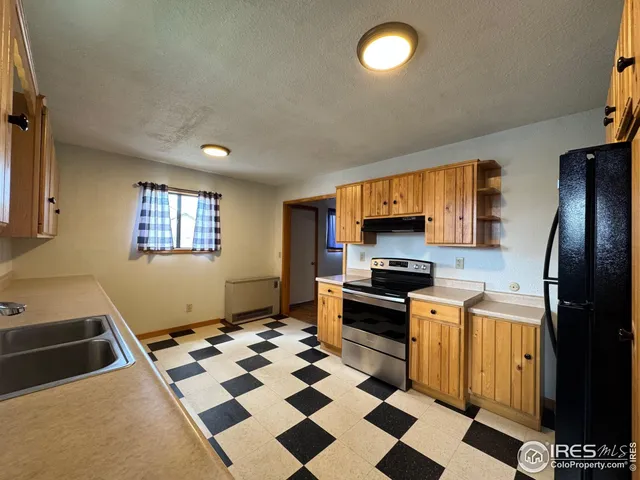 a kitchen with granite countertop stainless steel appliances a stove a sink and a refrigerator