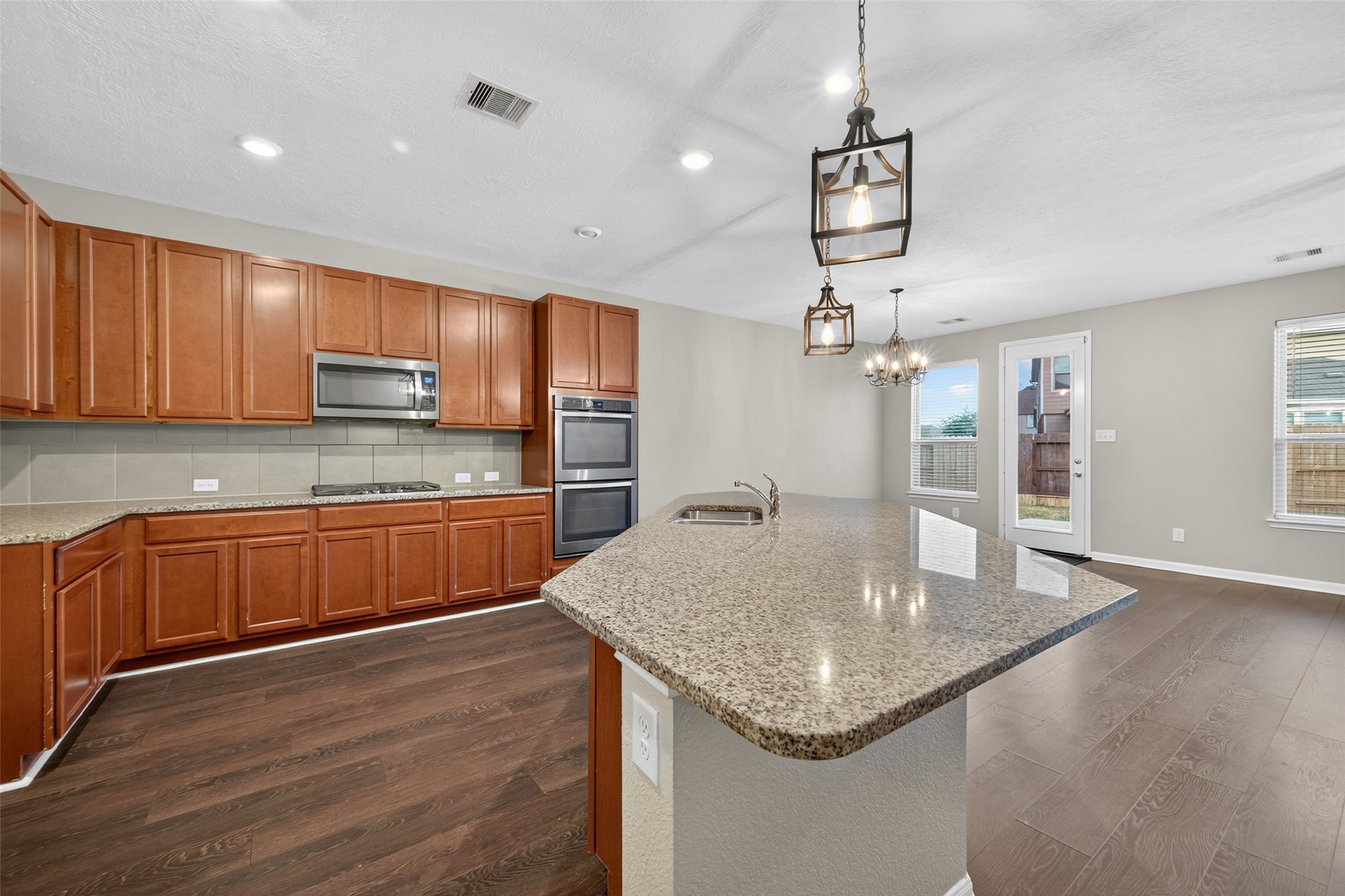 25403 King Reyes Street Katy, TX 77493 - Photo 6 of 27 a kitchen with stainless steel appliances granite countertop a sink dishwasher and microwave with wooden floor