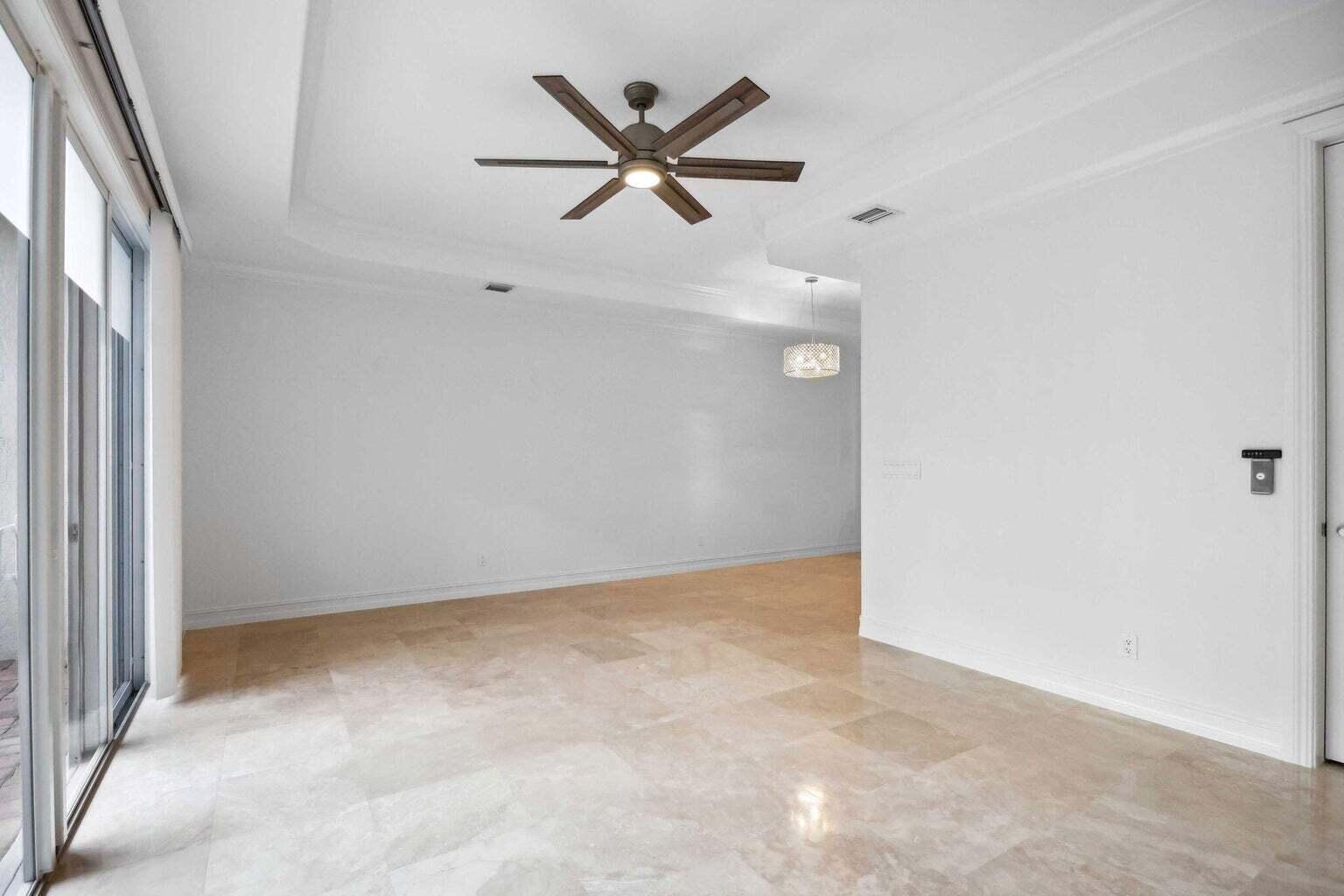 3873 Northeast 22nd Way Lighthouse Point, FL 33064 - Photo 11 of 43 an empty room with ceiling fan and windows