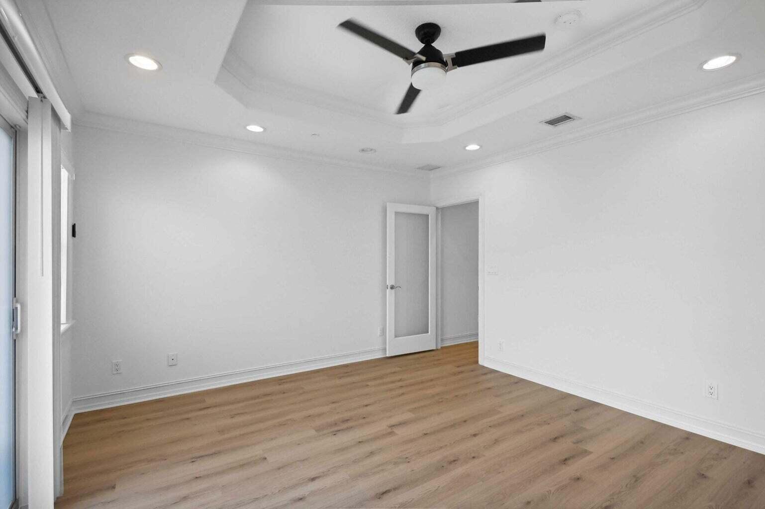 3873 Northeast 22nd Way Lighthouse Point, FL 33064 - Photo 20 of 43 an empty room with wooden floor ceiling fan and window