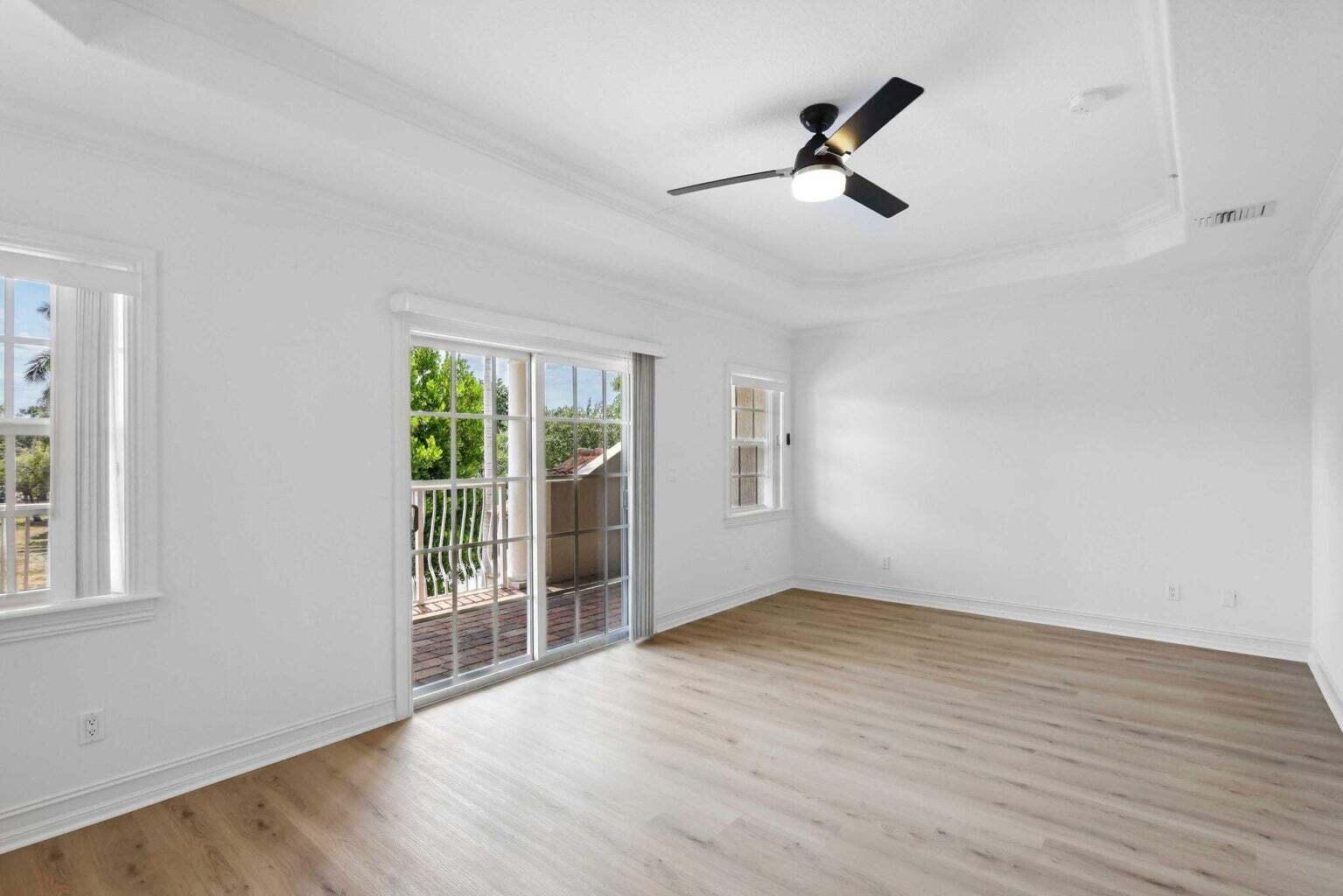 3873 Northeast 22nd Way Lighthouse Point, FL 33064 - Photo 21 of 43 a view of empty room with wooden floor and fan