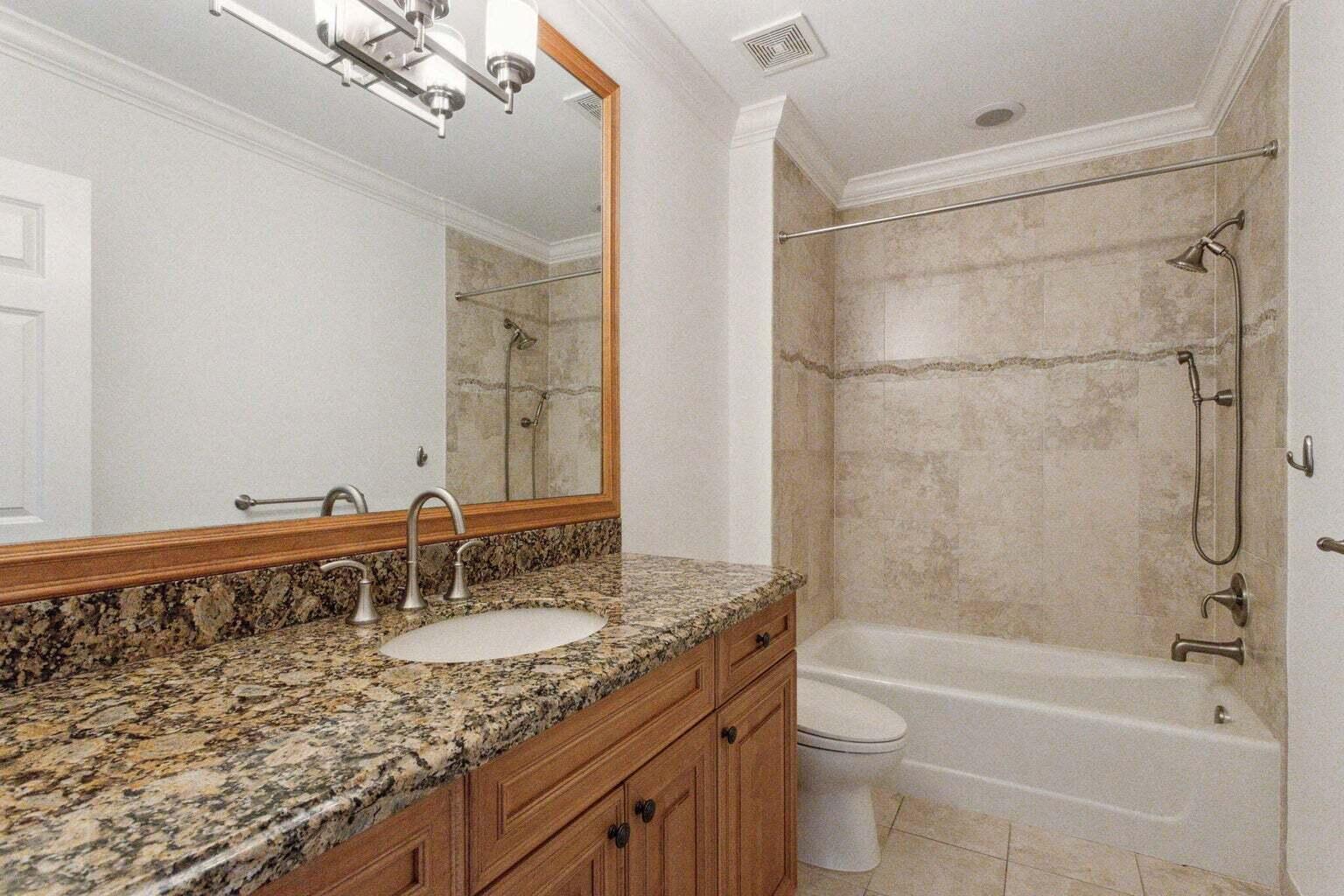 3873 Northeast 22nd Way Lighthouse Point, FL 33064 - Photo 27 of 43 a bathroom with a granite countertop bathtub shower sink vanity and toilet