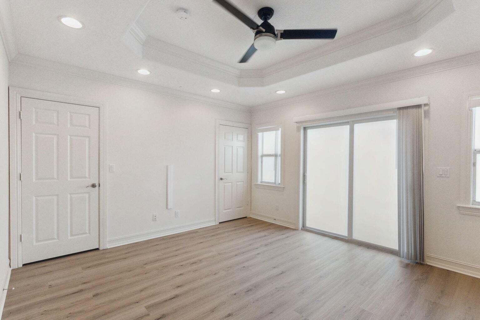 3873 Northeast 22nd Way Lighthouse Point, FL 33064 - Photo 30 of 43 an empty room with wooden floor ceiling fan and windows