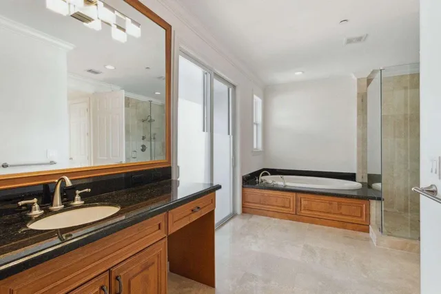 a bathroom with a granite countertop sink a mirror and shower