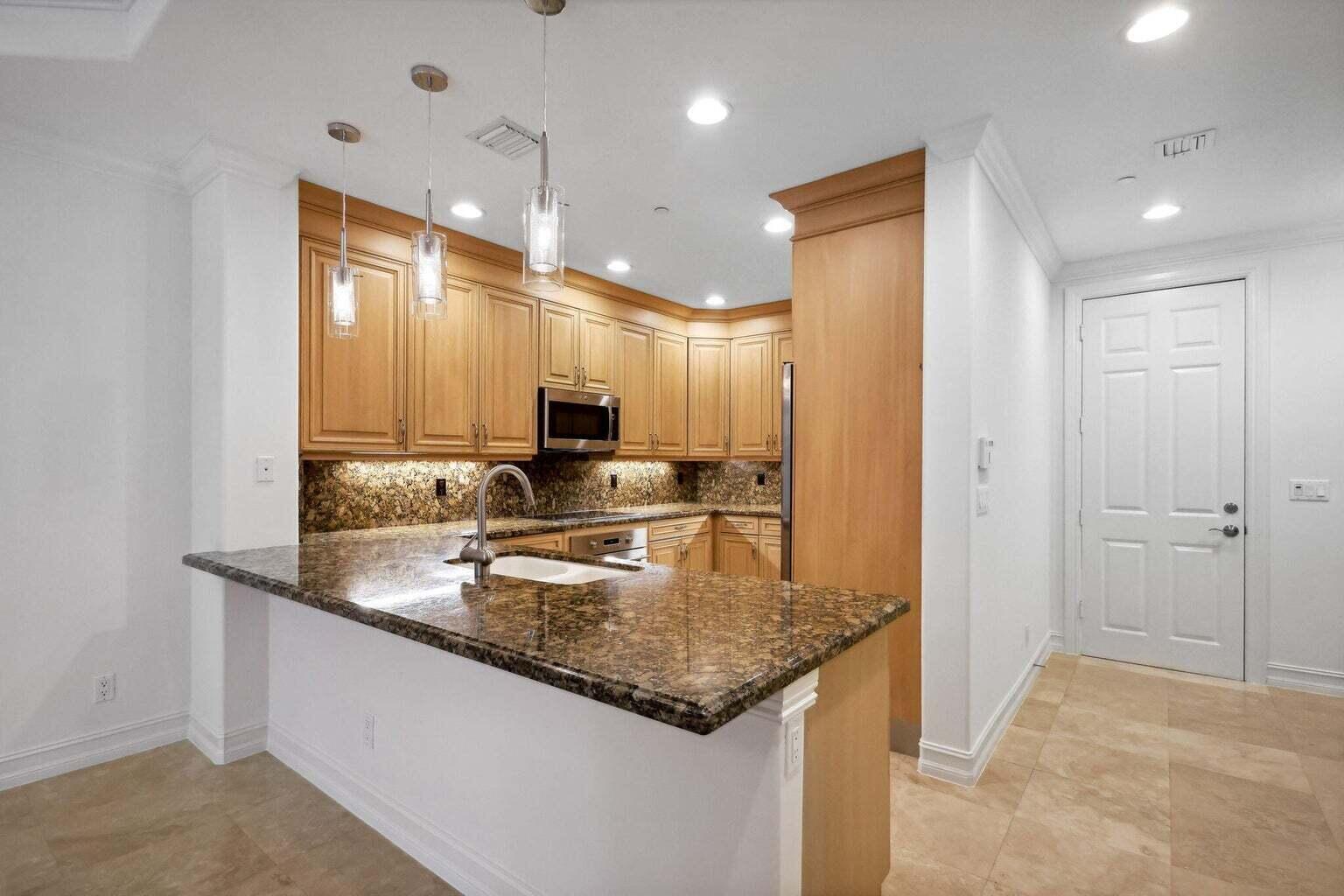 3873 Northeast 22nd Way Lighthouse Point, FL 33064 - Photo 4 of 43 a kitchen with kitchen island granite countertop a sink and refrigerator