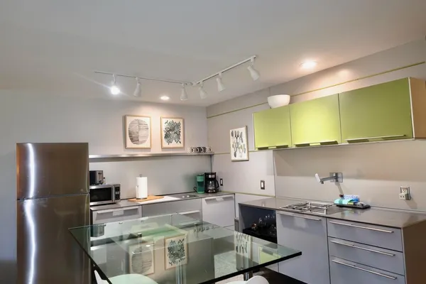 a kitchen with a sink a refrigerator and cabinets