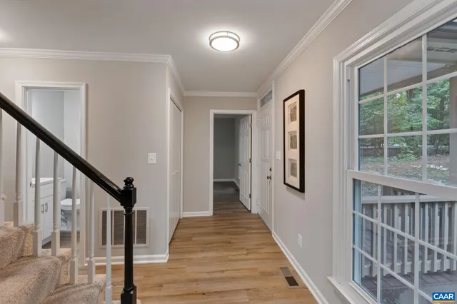 a view of a hallway with wooden floor and staircase